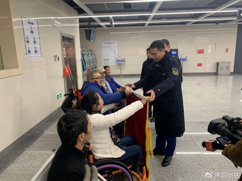 乘客亲手将锦旗交至车站工作人员手中