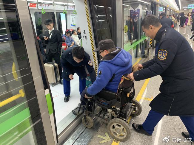 车站工作人员将乘客安全送上地铁