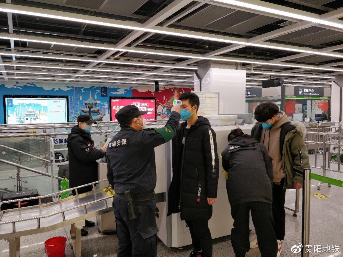 安检人员对乘客进行体温检测