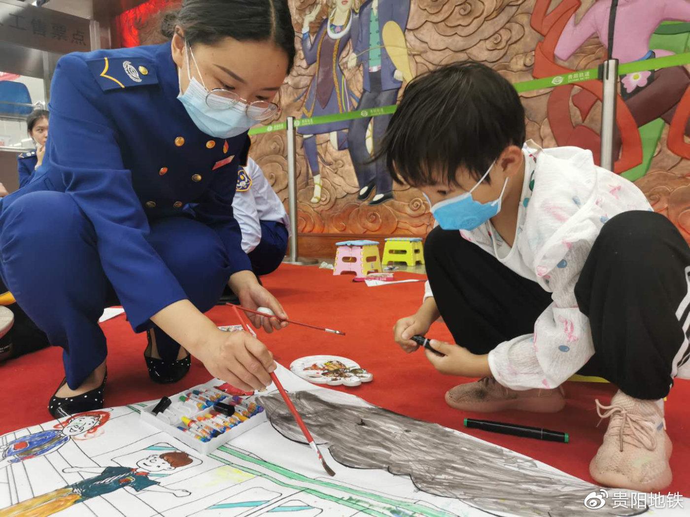 地铁绘画活动中,周雅芸与小朋友共同为“地铁”图画上色