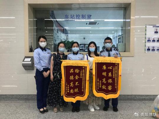 范女士向车站工作人员赠送锦旗，并与工作人员合影