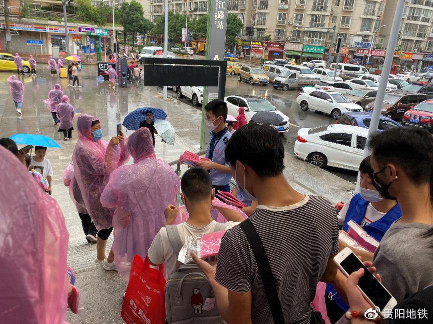 贵阳地铁1号线长江路站工作人员正在为乘客发放雨衣