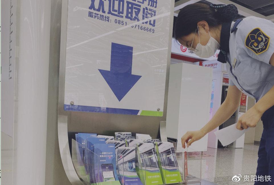 站务人员为地铁站内文明出行宣传手册进行补充整理