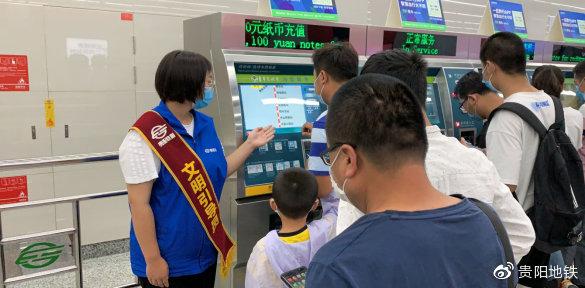 车站工作员工引导乘客购票