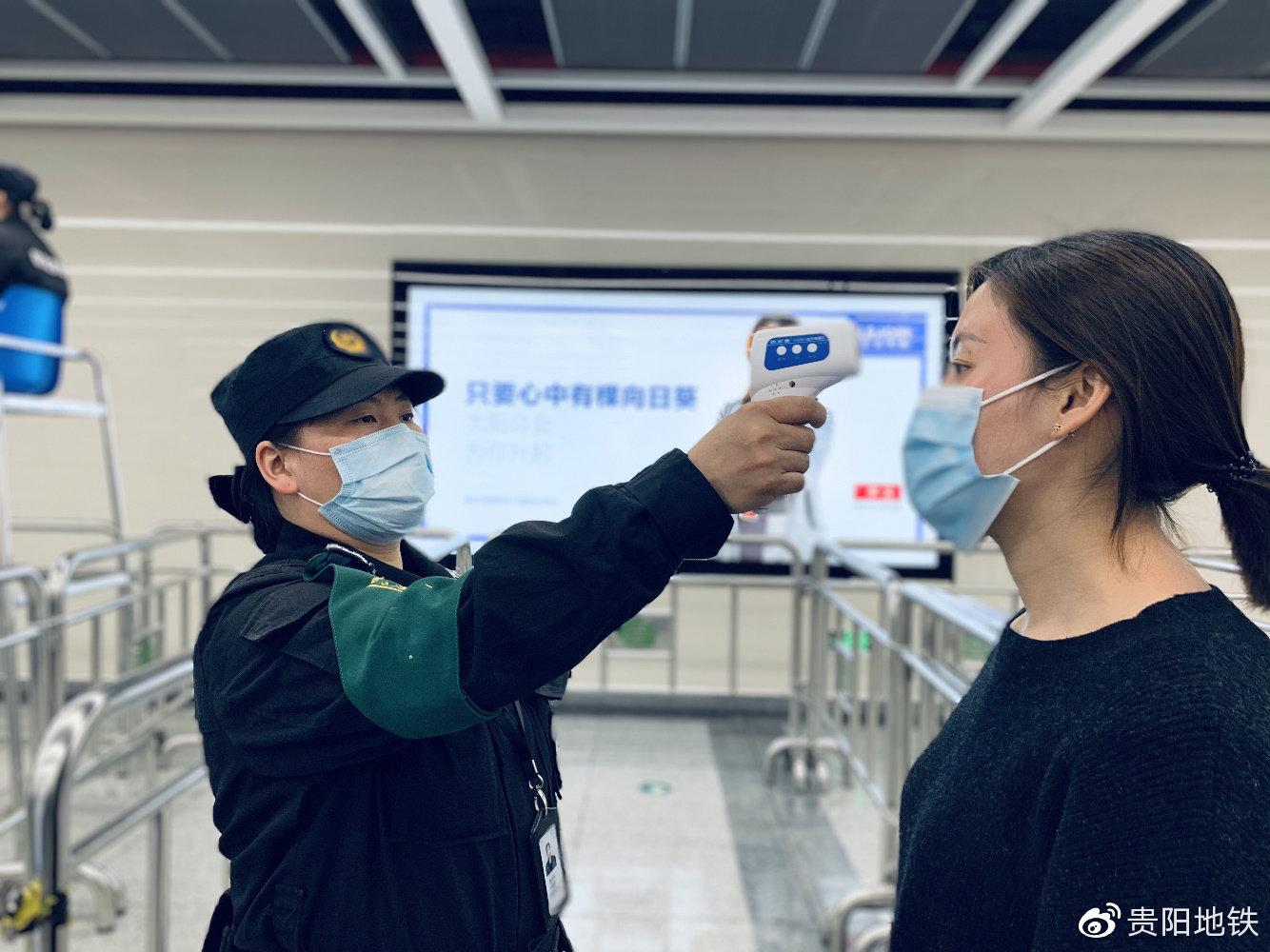 疫情期间工作人员为乘客测量体温